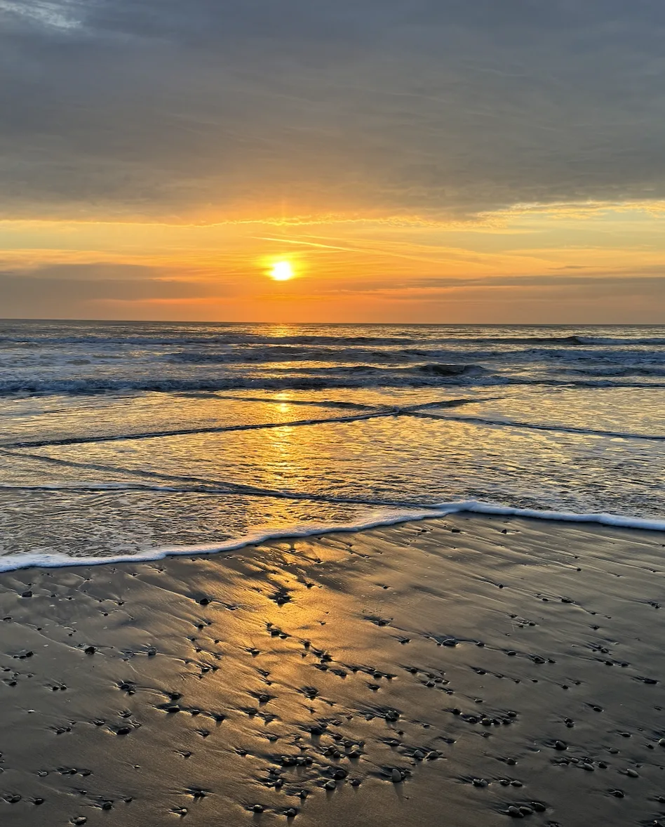 Sunrise over North Bay in Scarborough with waves on the beach and golden morning light on the Yorkshire coast